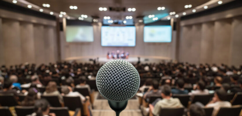 Microphone over the Abstract blurred photo of conference hall or seminar room with attendee background, Business meeting concept