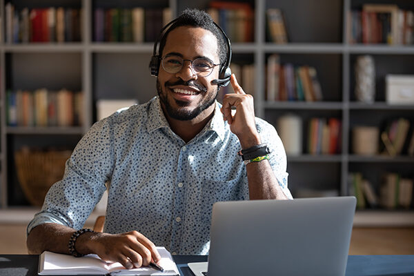 Happy young african american man wearing headset, looking at camera.